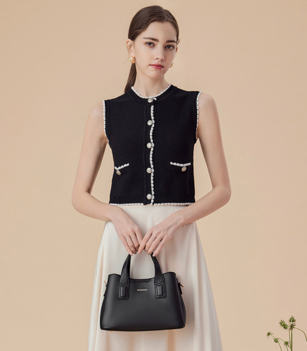 Model holding the black MOSSDOOM Cerise tote bag.