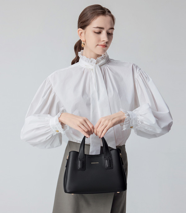 Model in a white shirt with the black MOSSDOOM Cerise handbag.
