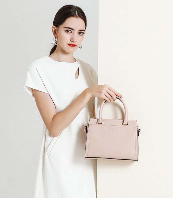 MOSSDOOM AMANDE Apricot color tote bag, carried by hand by a model.