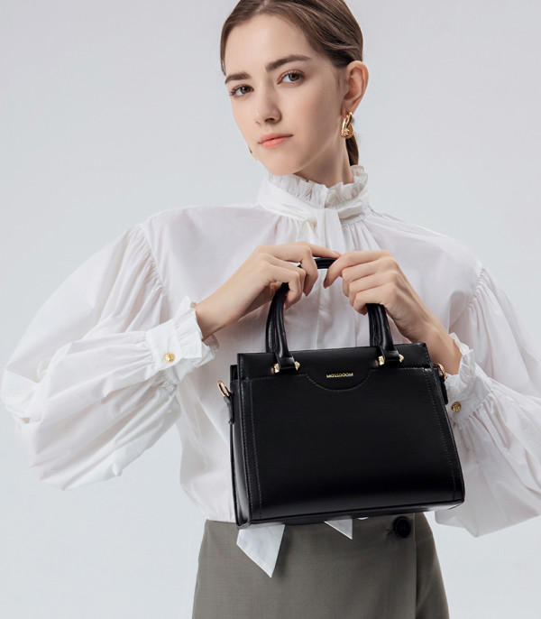 MOSSDOOM AMANDE black color tote bag, held by a model in a white shirt.