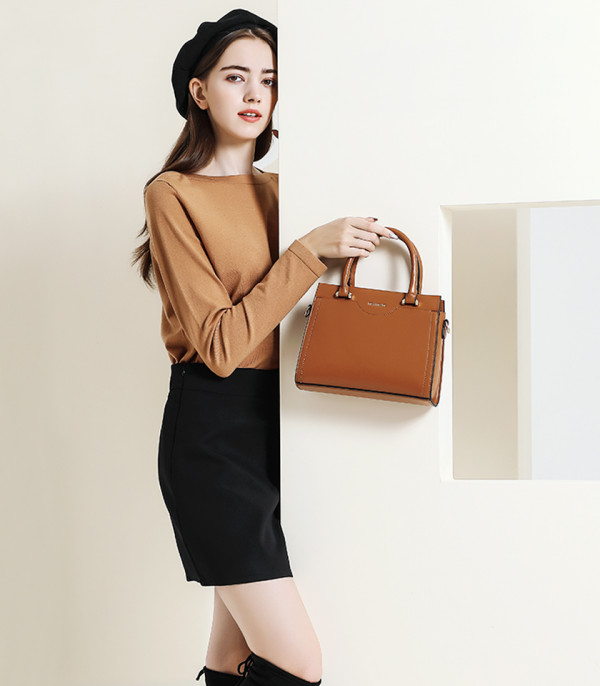 Model presenting the MOSSDOOM AMANDE Camel color tote bag, carried by hand.