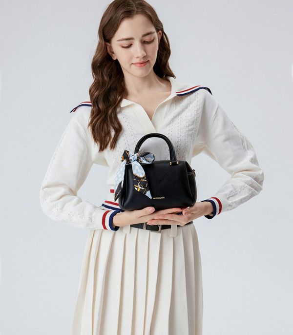 Model holding the MOSSDOOM MARCIA top handle bag, Black color.
