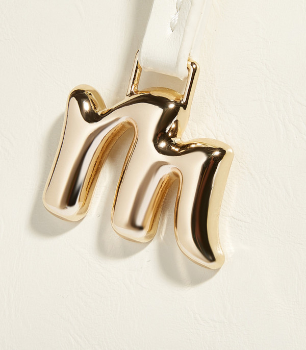 Close-up on the gold M charm of the MOSSDOOM REYNA shoulder bag.
