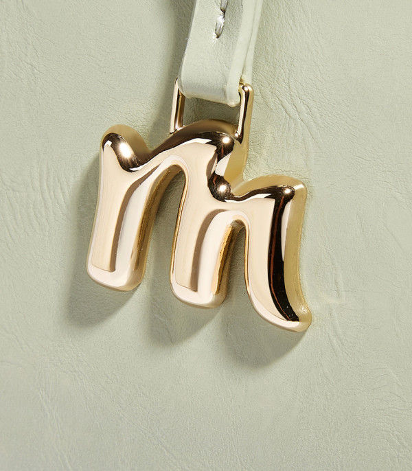 Close-up on the gold M charm of the MOSSDOOM REYNA shoulder bag.