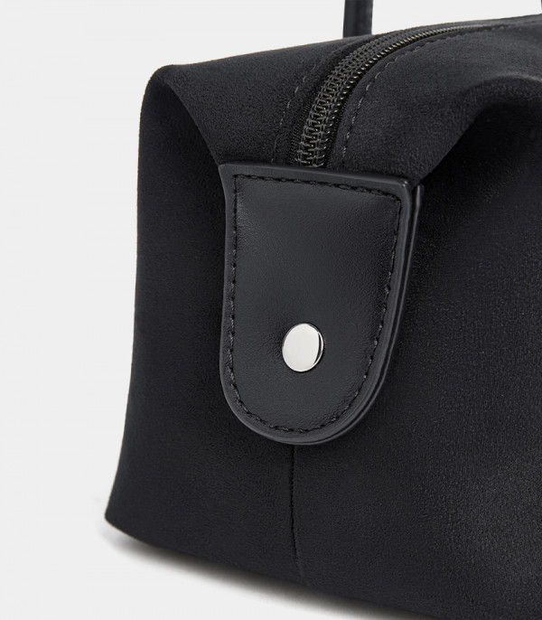 Close-up on the side snap button of the MOSSDOOM PAULA baguette bag.