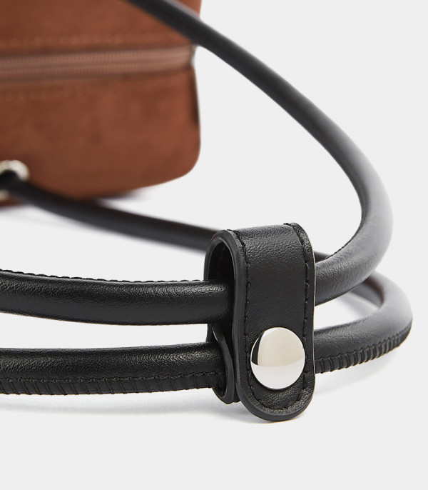 Close-up on the handle attachment of the MOSSDOOM PAULA baguette bag.