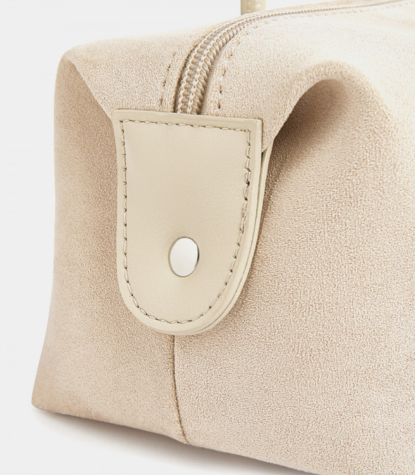 Gros plan sur le bouton pression latéral du sac baguette MOSSDOOM PAULA.
