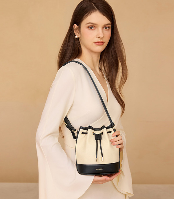 Modella che indossa la borsa a secchiello MOSSDOOM Alicia bicolore nera a spalla.