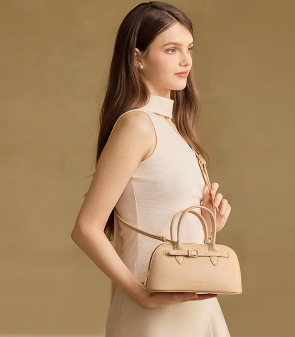 Borsa a mano MOSSDOOM Alaura beige portata a spalla da una modella.