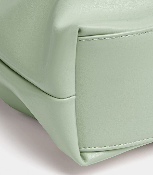 Close-up on the base and stitching of the green Danica tote bag.