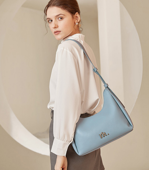 Model wearing the MOSSDOOM Deanna crossbody bag in sky blue.