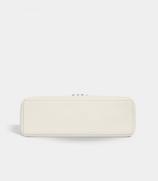 Bottom view of the Deanna ivory handbag, showing the flat base.