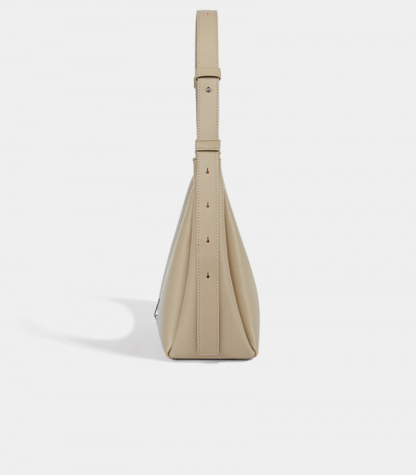 Profile of the Deanna cream handbag showing the adjustable strap details.