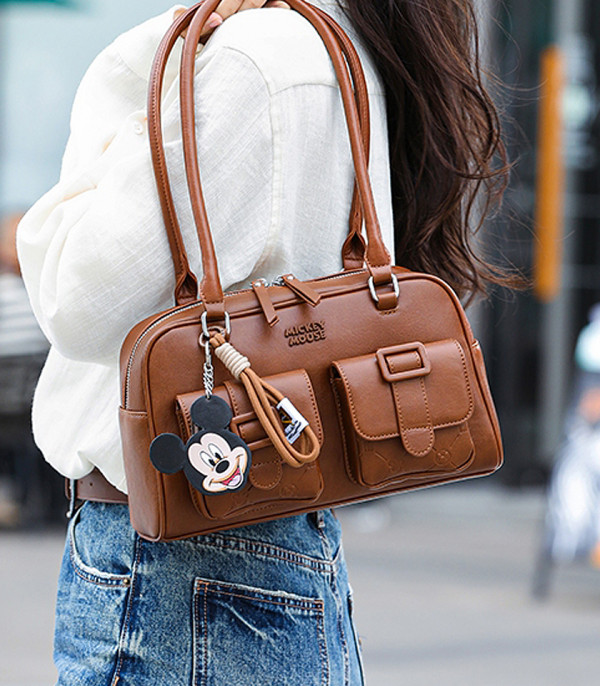 Model wearing the DISNEY MICKEY MOUSE bowling bag, Camel color, on her shoulder.